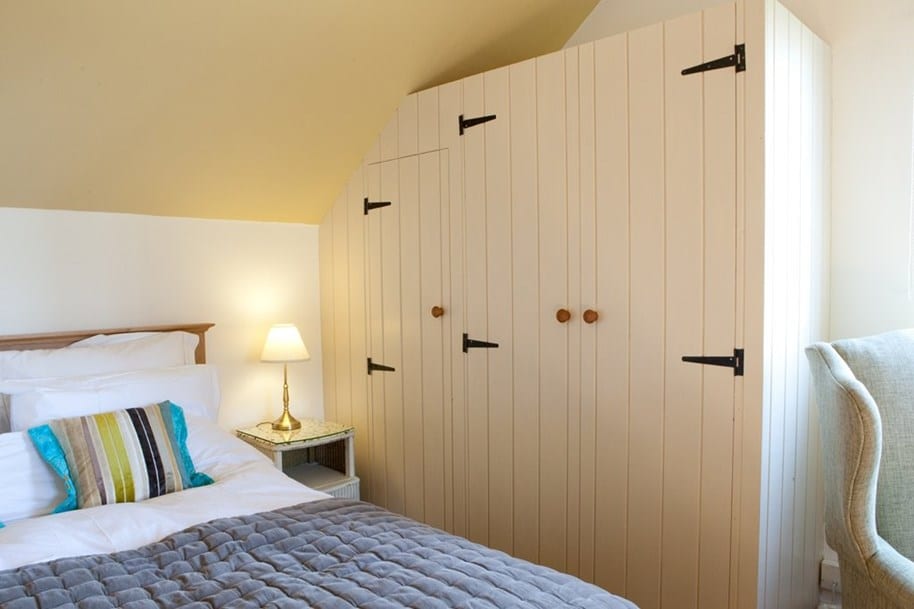 Bespoke fitted wardrobes in a bedroom in Witney. Handcrafted by Neil Bathgate Joinery and finished in matt white